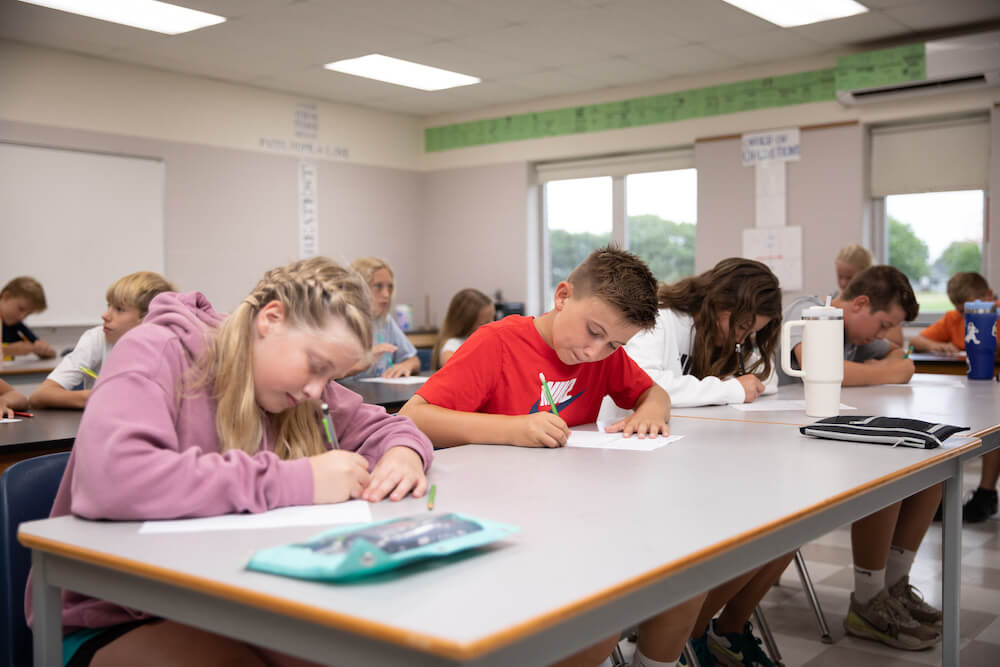 Middle school students writing at desks at HCS