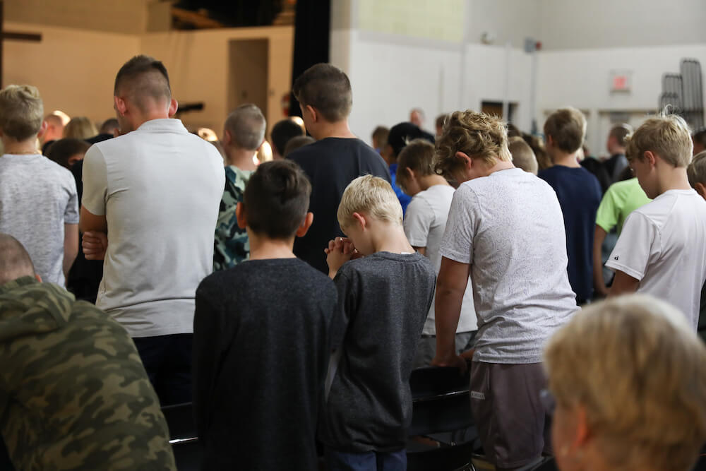 Middle school students praying during chapel at Hudsonville Christian School.